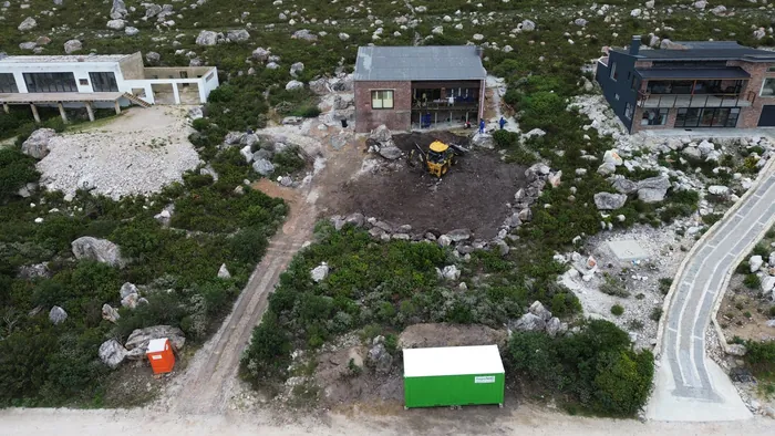 The ground opened up alongside the existing house for the new level, with the site set up at the road